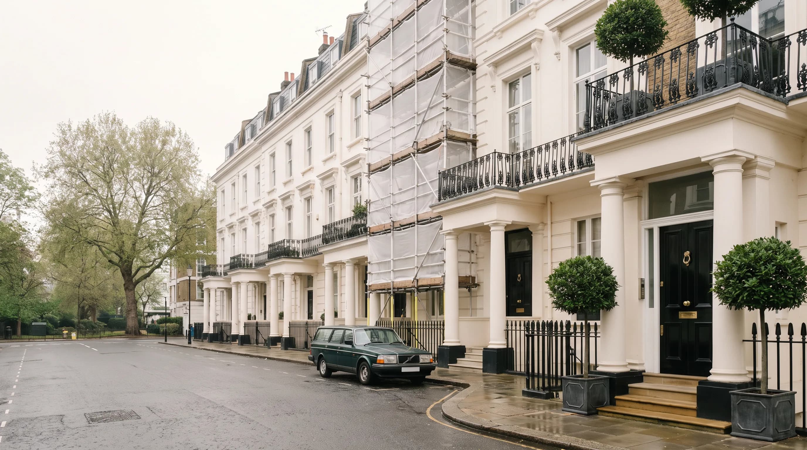 A west London terrace of stucco-fronted townhouses, one with a side-return extension under construction.