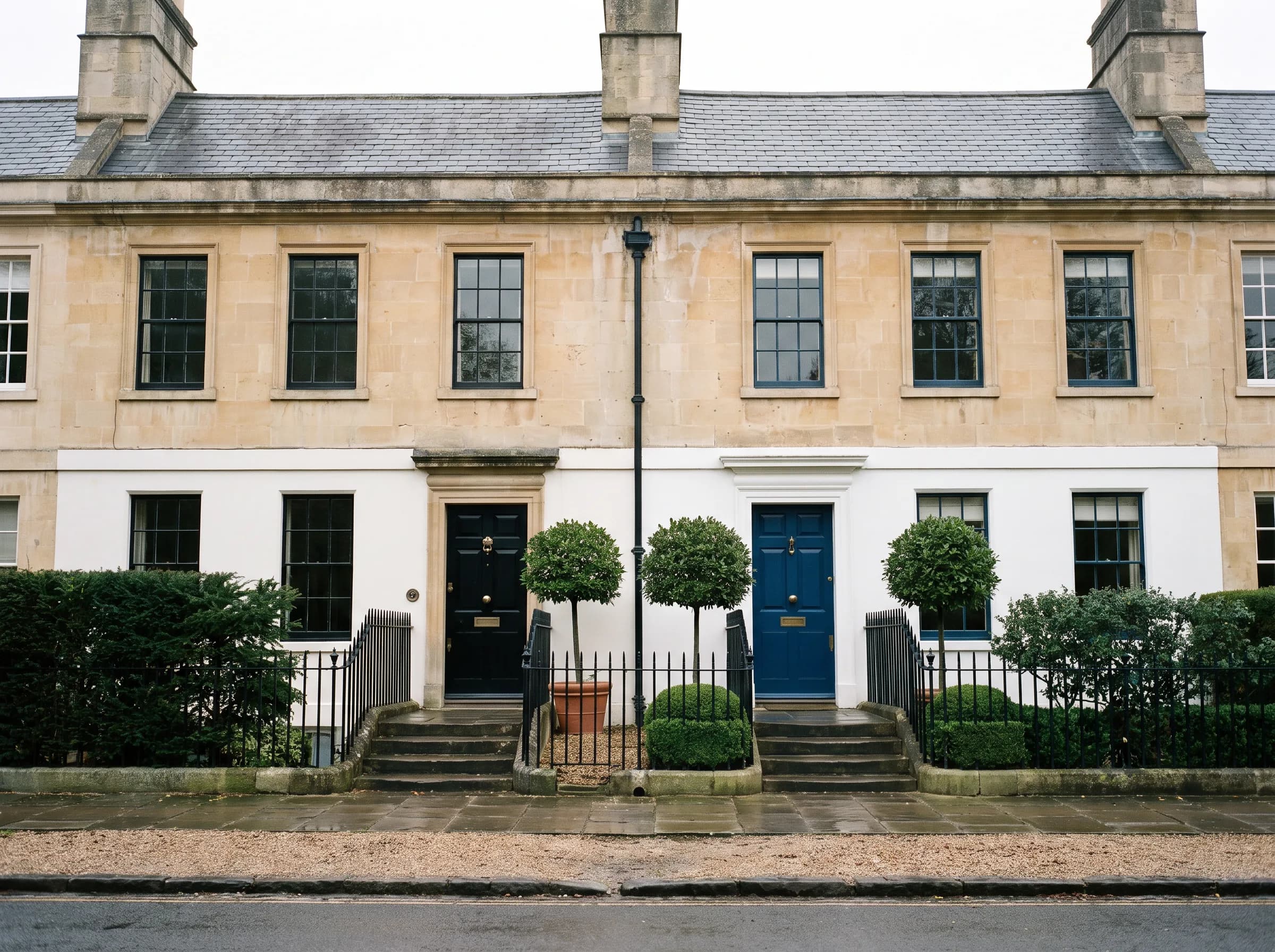Two adjoining Georgian townhouses that share a party wall, seen from the street.